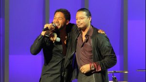 Lupe Fiasco stands with Terrance Howard on stage