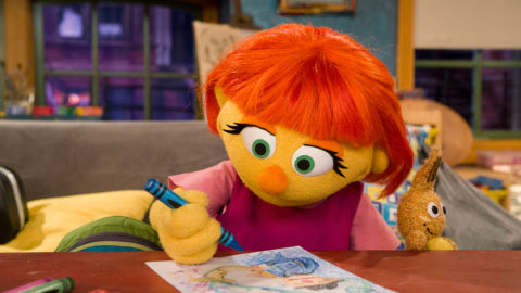 Sesame Street character Julia colors with a crayon