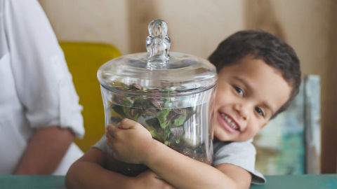 A boy hugging a glass jar