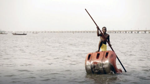 A boy rows in a lake in modern-day Benin.