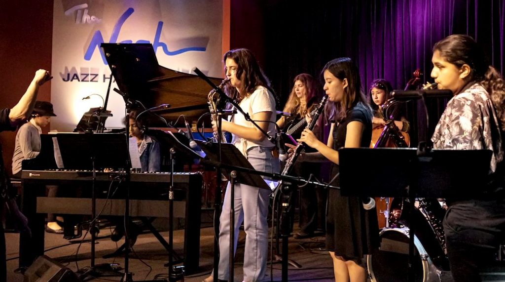 Jazz girls performing a concert with varius instruments.