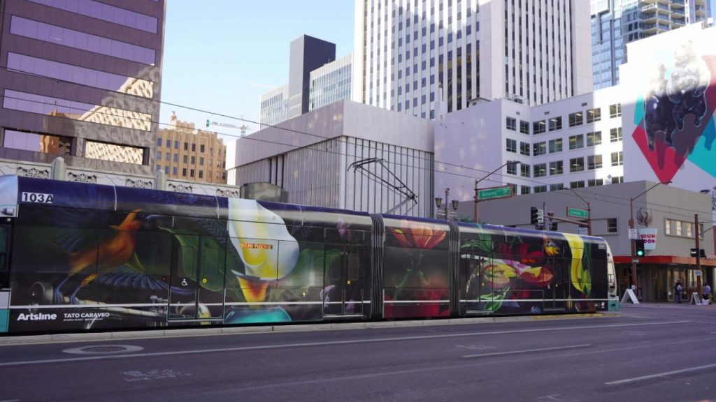 Lightrail with colorful flowers and hummingbirds driving through Phoenix.