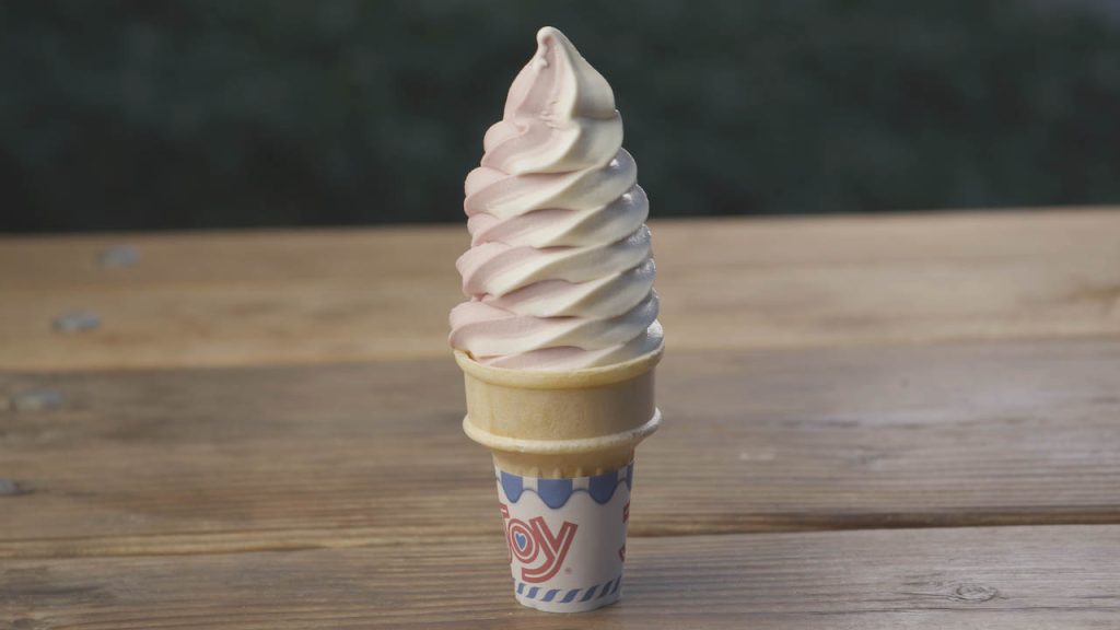 A cone of soft serve ice cream from Topo stands on a wooden table.