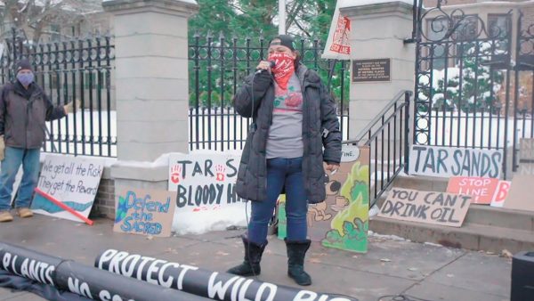 protestor stands in front of signage