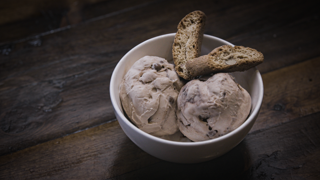 Gelato with biscotti sits in a bowl on a table