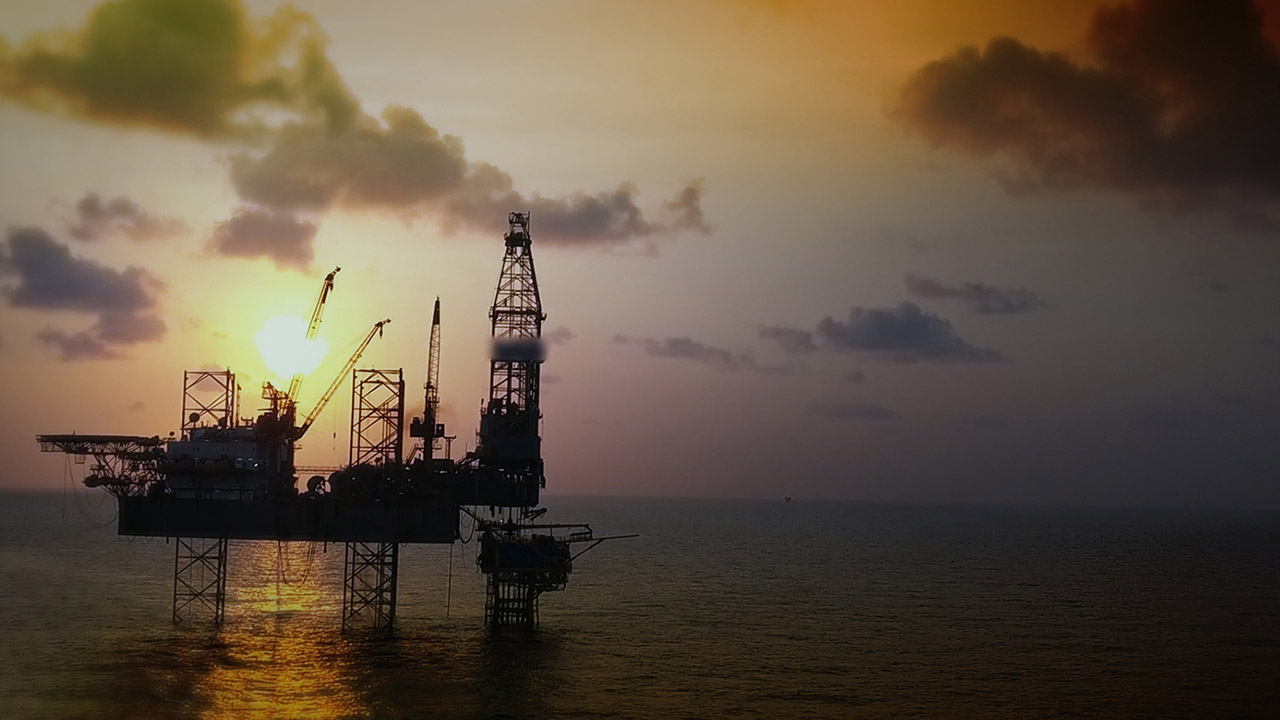 Aerial view of offshore jackup drilling rig during sunset.