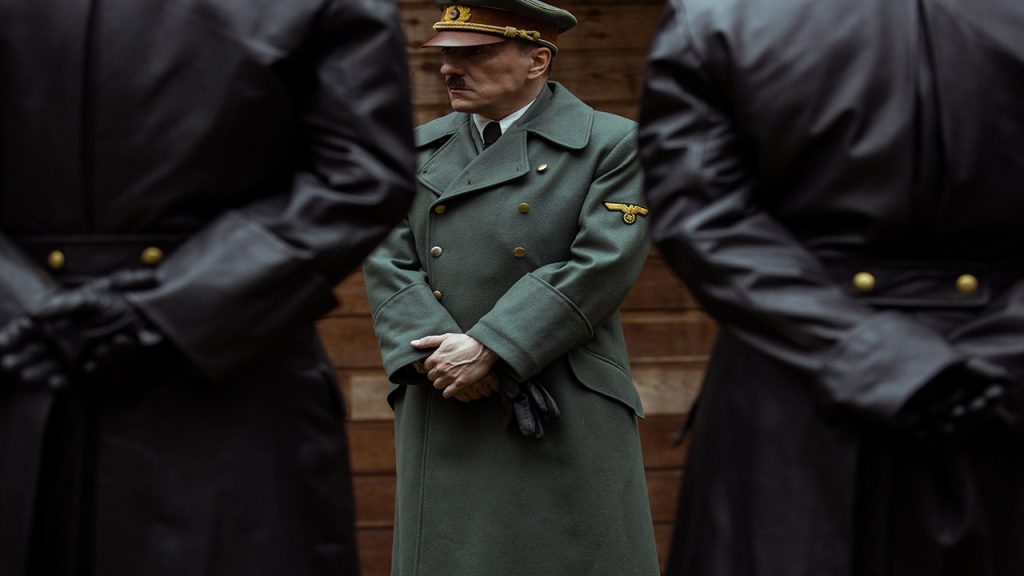 Adolf Hitler stands between two guards