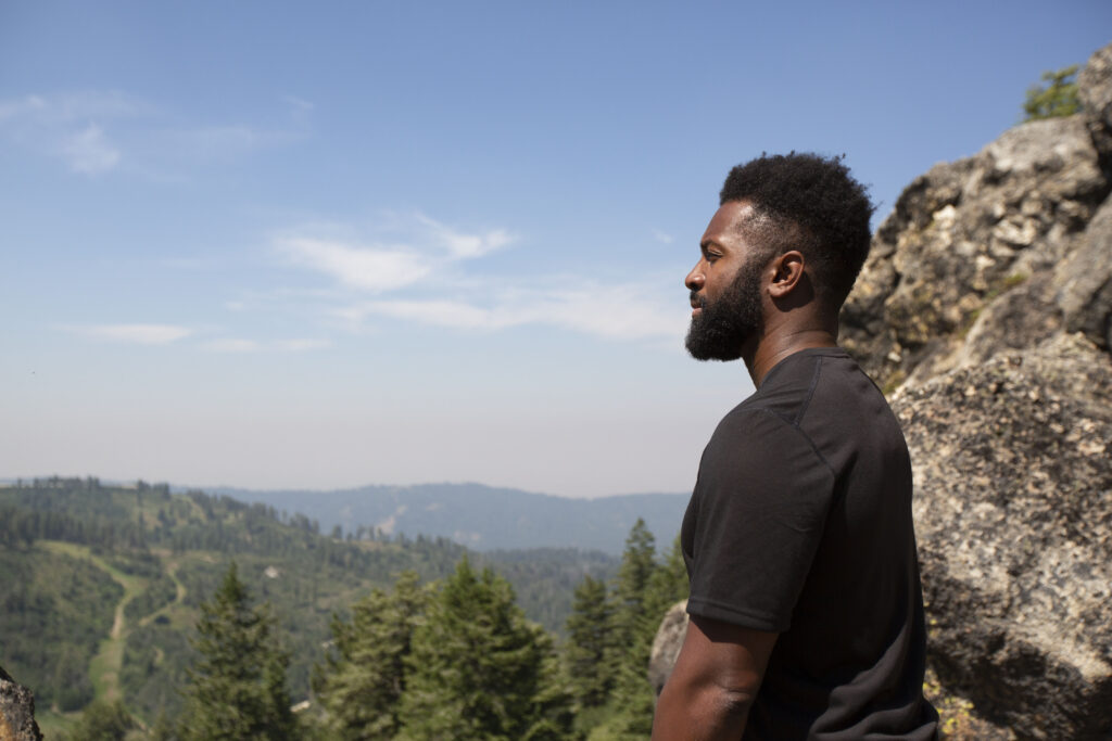 Baratunde Thurston looking out into nature from a cliff
