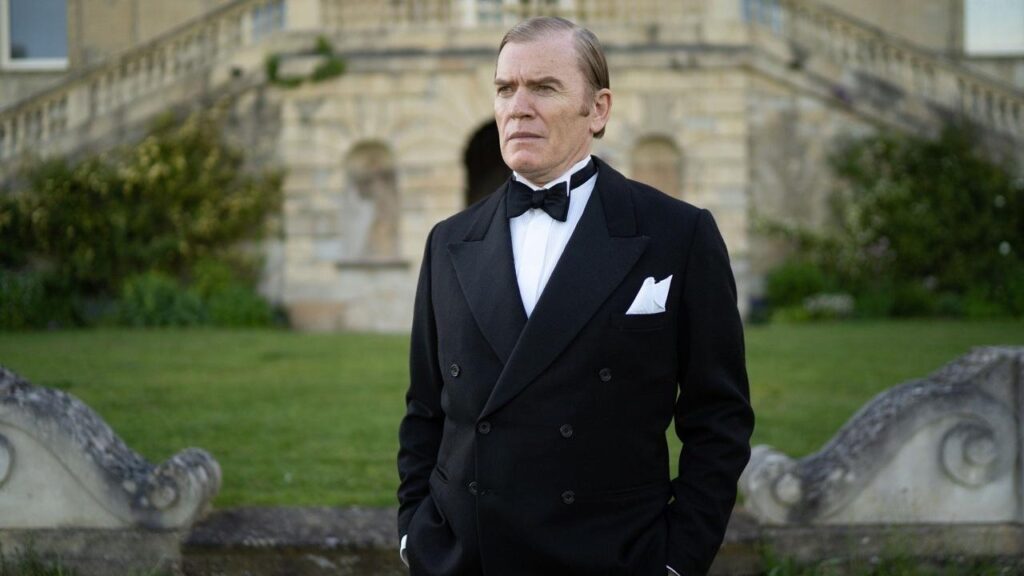 A character ffrom father brown is wearing a tuxedo.