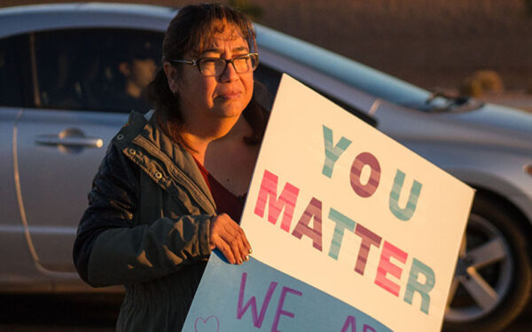 A woman holds up a sign reading You Matter.