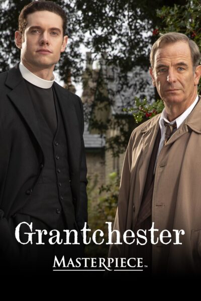 Tom Brittney and Robson Green, in character as Will Davenport and Geordie Keating, stand outside with the villiage behind them.