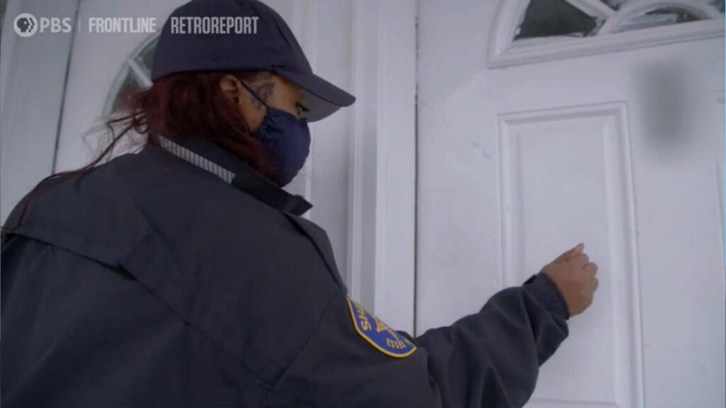 A police officer knocks on a front door