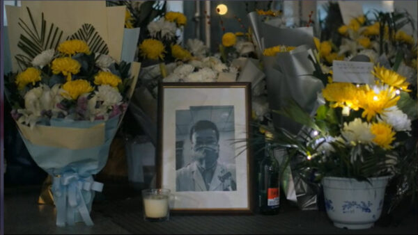 A memorial with flowers and a photo for a doctor who died from the coronavirus