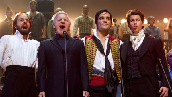Stars of Les Miserables stand together on stage.