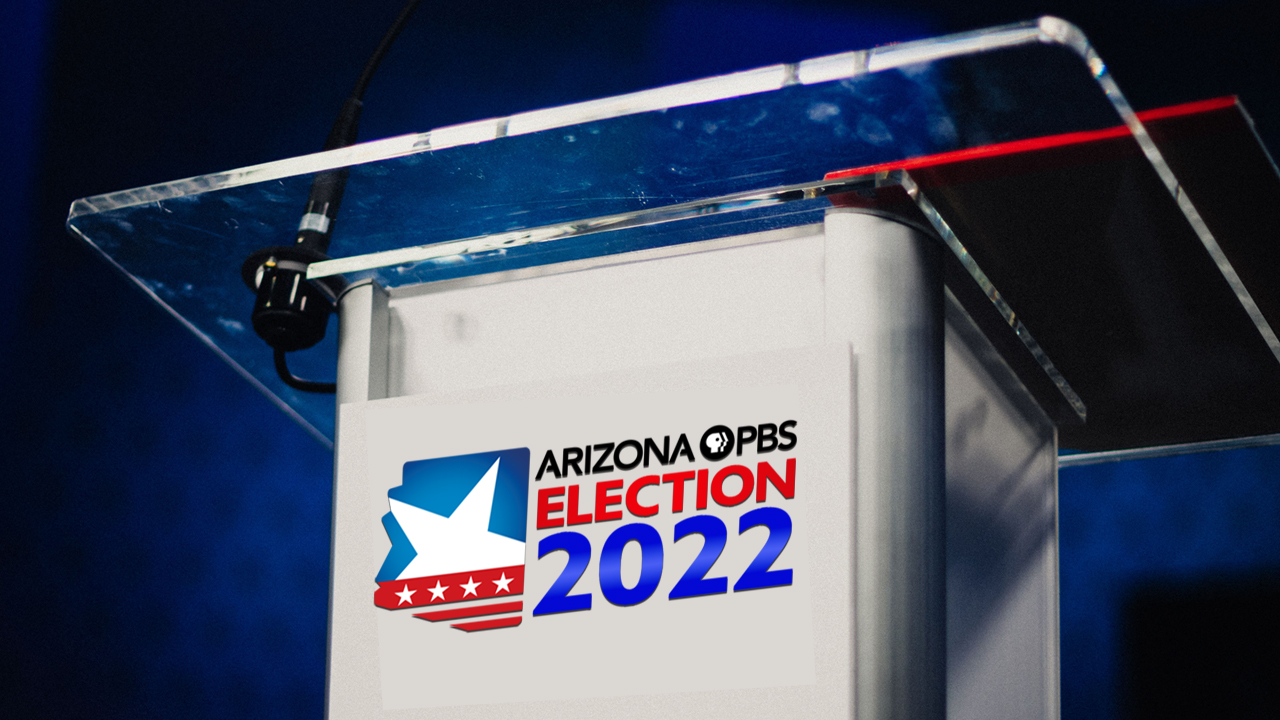 A close up look at a debate podium with a clear top and the Arizona PBS Election 2022 logo