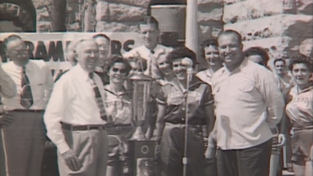 screenshot of group of people surrounding a trophy. screenshot from Arizona memories