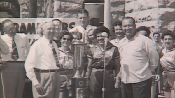 screenshot of group of people surrounding a trophy. screenshot from Arizona memories