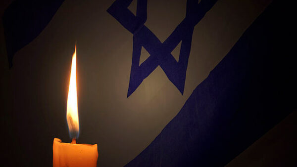 lit candle in front of Israeli flag
