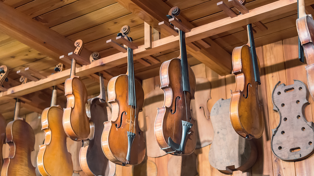 unfinished violins hanging from a shelf