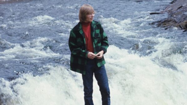 John Denver stands by a stream in his special Rocky Mountain High