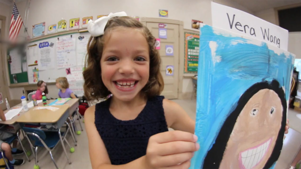 A young girl shows a painting she made