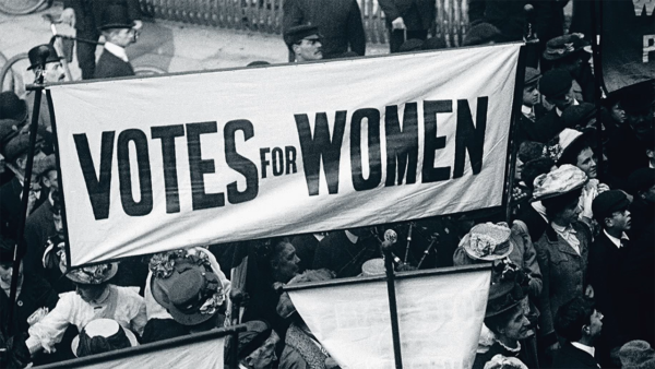 Banner that says Vote for Women with a group of women protesting