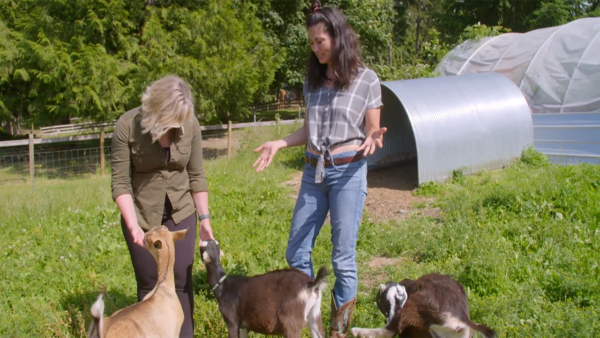 Sabrina Tinsley and Rachel Taylor petting some goats
