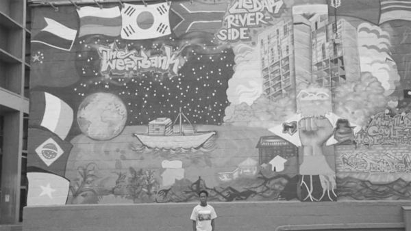 black and white image of someone standing infront of a mural