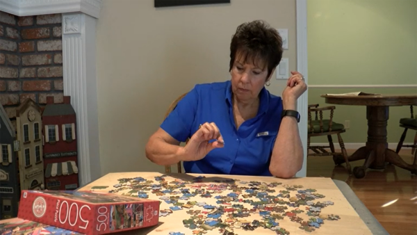A woman works on a puzzle at home during the pandemic