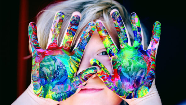 A young child takes part in finger painting
