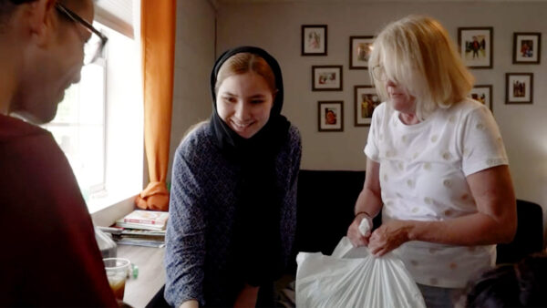 A neighbor helps her new neighbors who happen to be immigrants