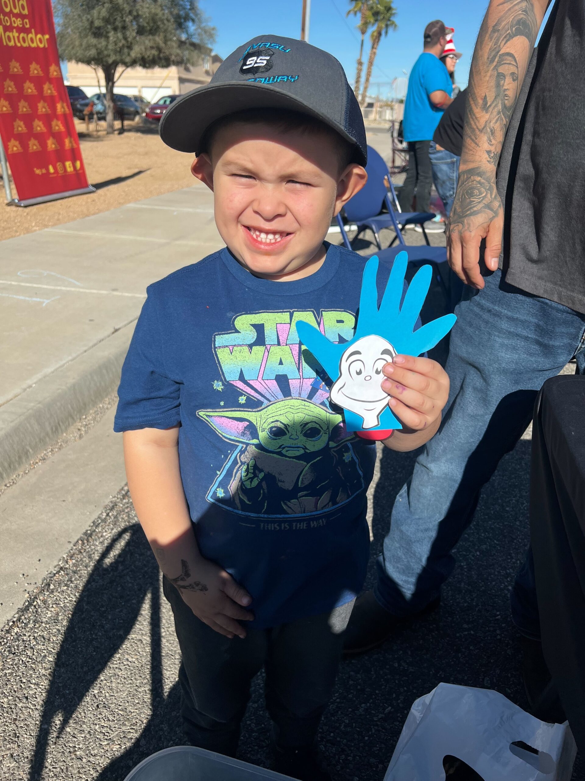 A child poses with his Cat in the Hat craft.