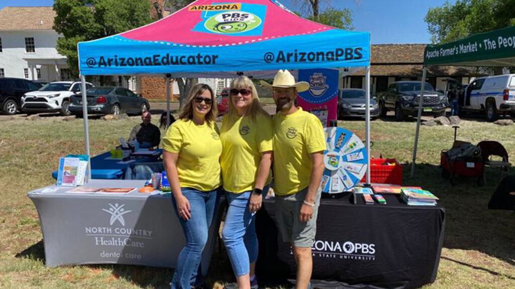 AZPBS Education team members pose in front of an AZPBS booth.