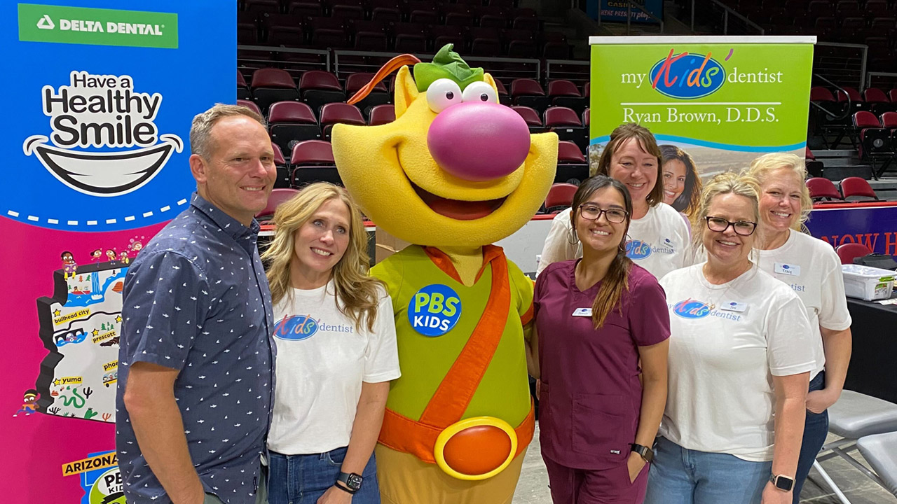 Dental techs and volunteers stand next to Nature Cat during a health fair in Prescott Valley