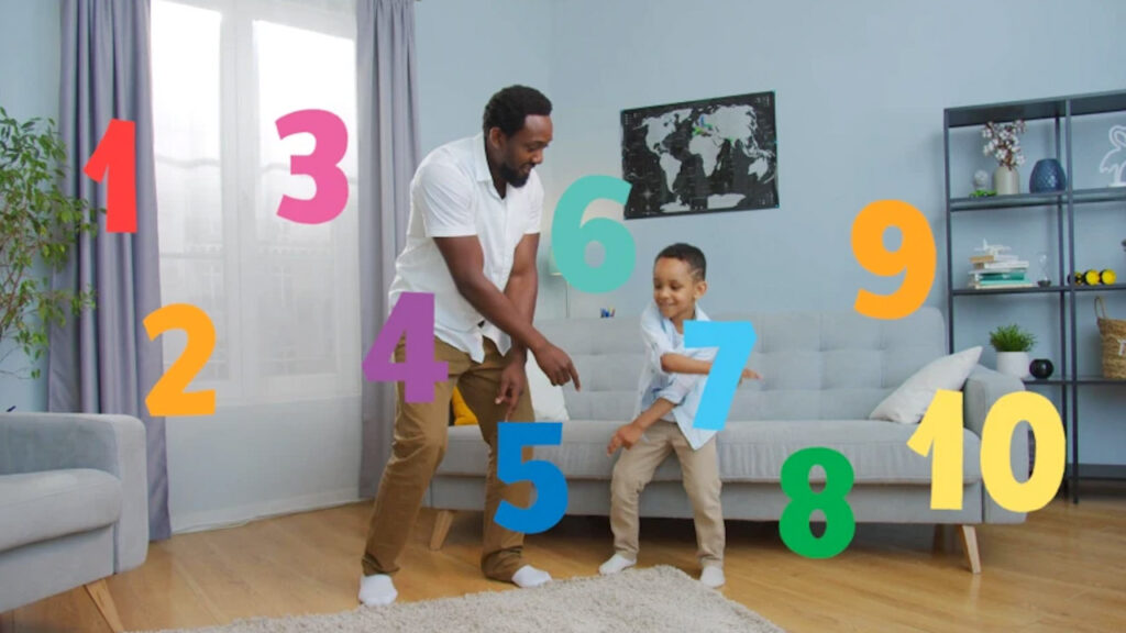 A father and son dance in their living room