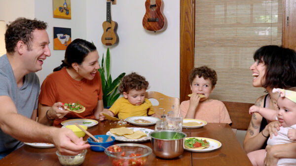 A hispanic family gathers around a table for a meal