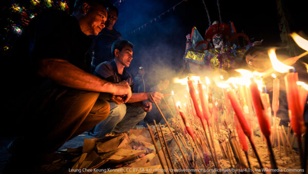 people kneeling in front of flames feeding hungry ghosts
