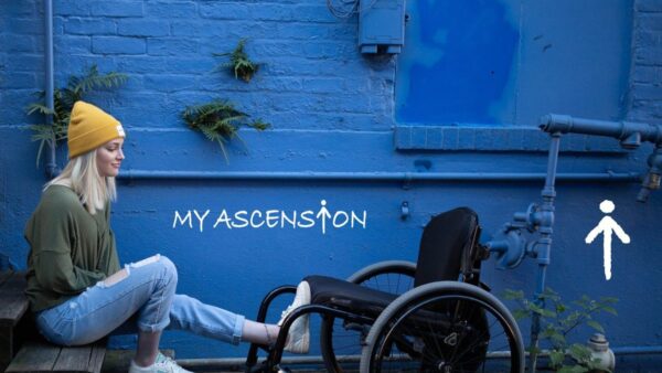 A young woman sits on a bench next to her empty wheelchair