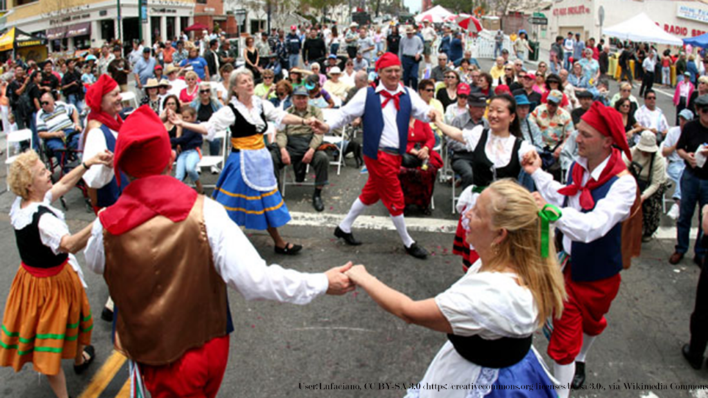 group of people in traditional Italian garb dancing the tarentella