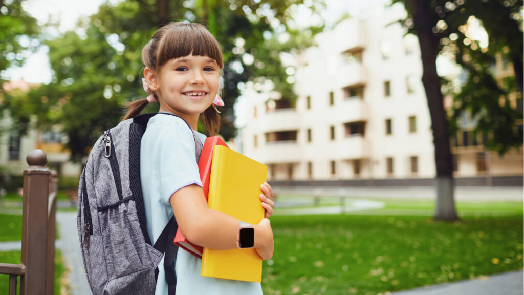 A girl on her way to school, wearing her backpack and a smartwatch