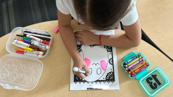 A young student works on an activity celebrating Day of the Dead