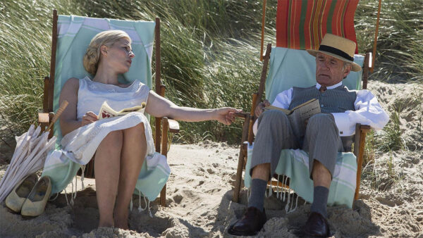 A man and woman relax on beach chairs in the shade on the beach