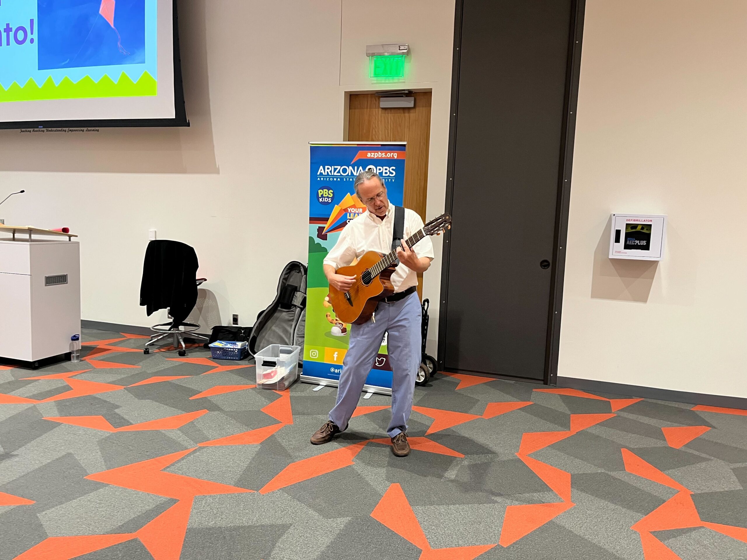 Gordon plays guitar and sings at an AZPBS Family Math event