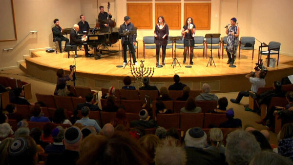 Singers perform on stage during a Hanukkah program
