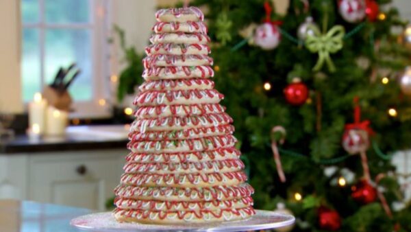 Paul’s Kransekake, a delicious dessert, piled high on a plate on a counter near a Christmas tree