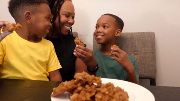 An African American mother and her two children enjoy Jamaican coconut drops