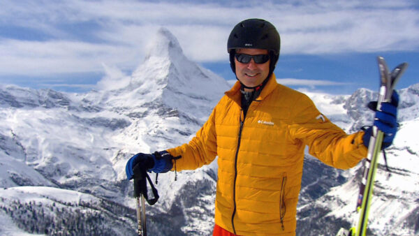 Jeff Wilson stands in the Alps on his skis with the Matterhorn behind him