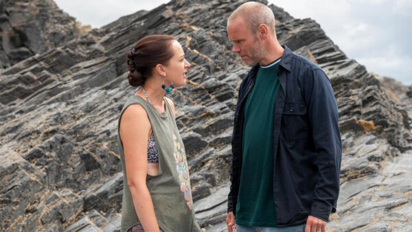 Two characters from Doc Martin talking in front of rocks