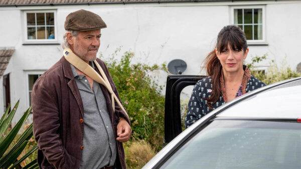 Two characters from Doc Martin standing in front of a car