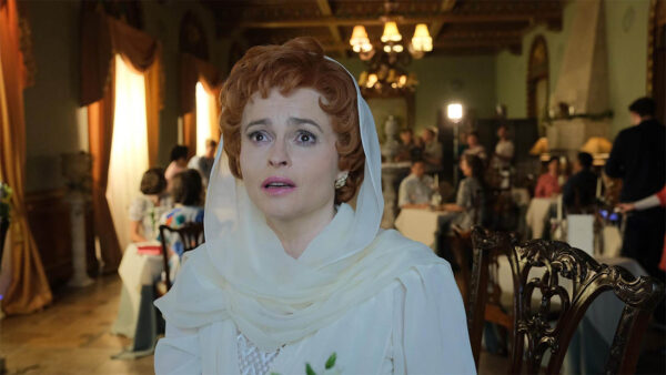 Nolly, played by Helena Bonham Carter, standing and wearing all white. Nolly on Masterpiece